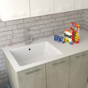 Mobile lavabo con lavabo bianco e rubinetto davanti a una parete di mattoni.