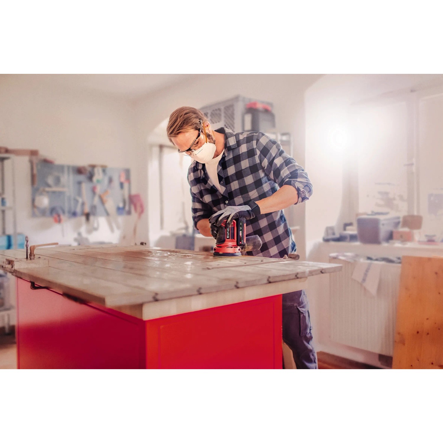 Levigatrice rotorbitale a batteria Einhell Power X-Change TE-RS 18 Li Solo mentre leviga un pannello di legno.