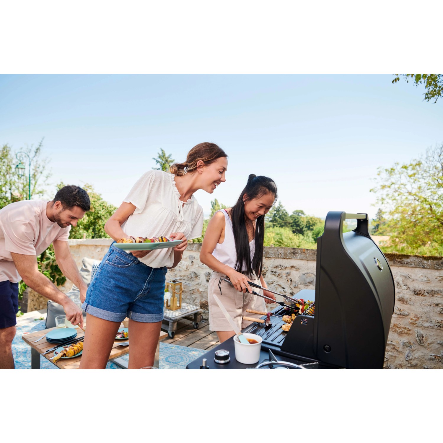 Gruppo che griglia all'aperto con barbecue a gas t.b.t. Divertimento con gli amici.