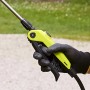 Primo piano di una mano che aziona una pompa a pressione giallo-nera.