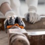 Spugna abrasiva Bosch Expert per legno e vernice in uso per levigare il legno.