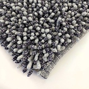 Dettaglio di un tappeto da bagno t.b.t. grigio con texture a ciuffi.