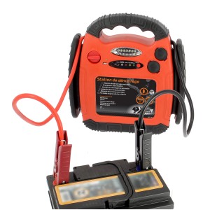 Booster di avviamento arancione con morsetti su batteria auto per manutenzione e riparazione.