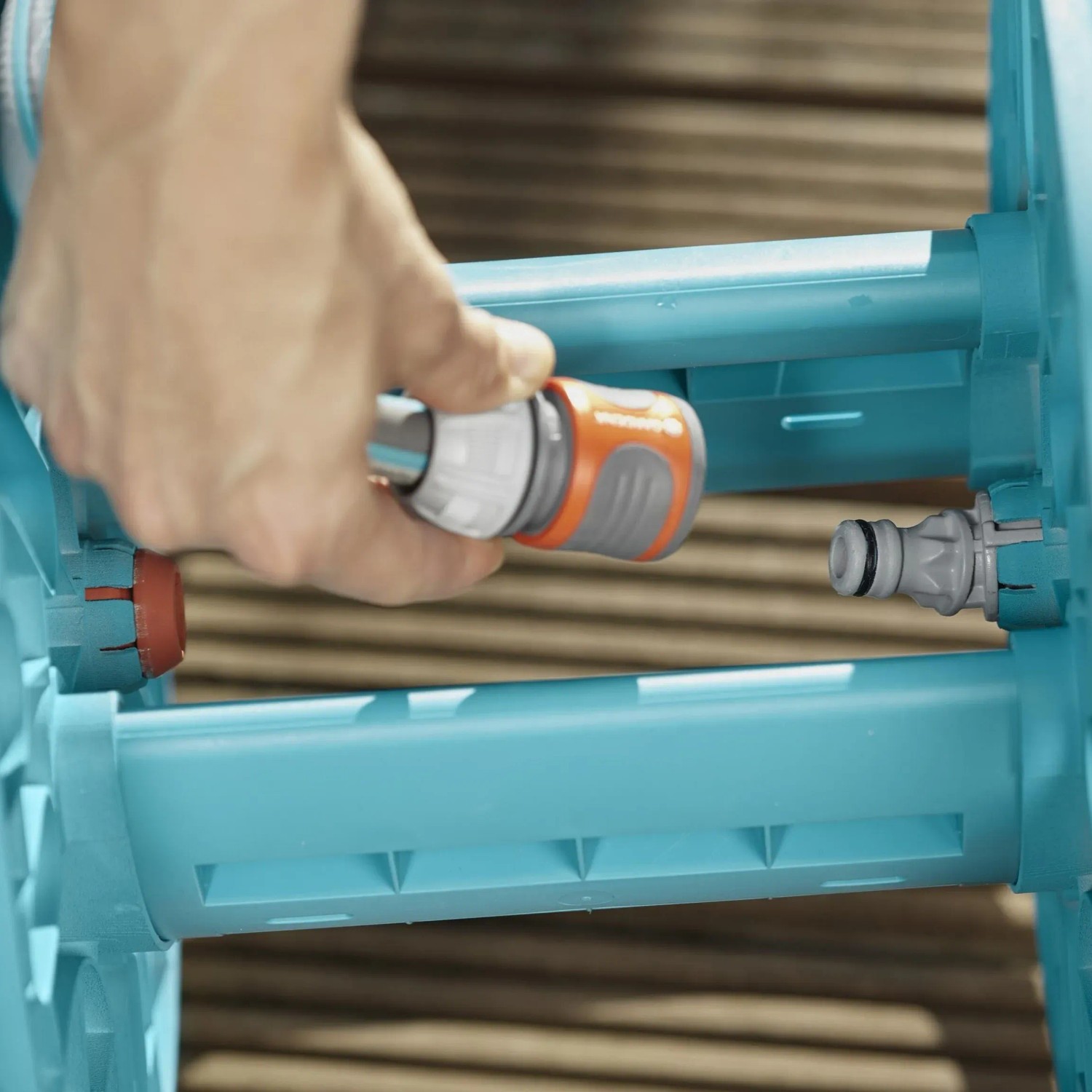 Carrello avvolgitubo Gardena CleverRoll S: mano collega raccordo al carrello.