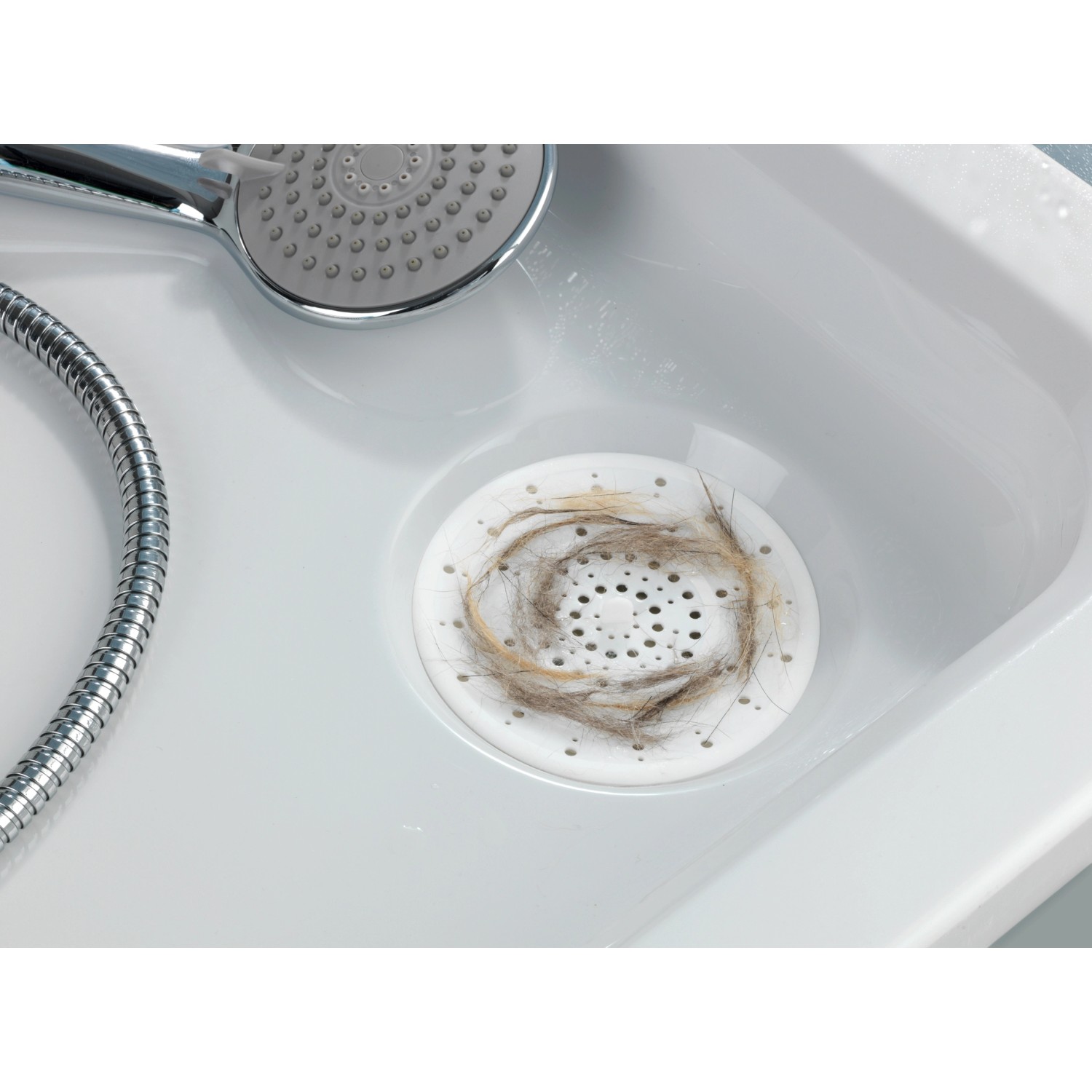 Filtro di scarico Wenko bianco in silicone nel lavandino, cattura i capelli.