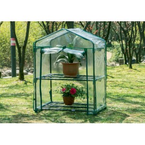 Piccola serra t.b.t. verde con due ripiani e piante in vaso.