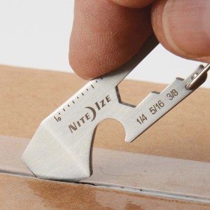 Multitool a moschettone Nite Ize che apre una scatola di cartone.