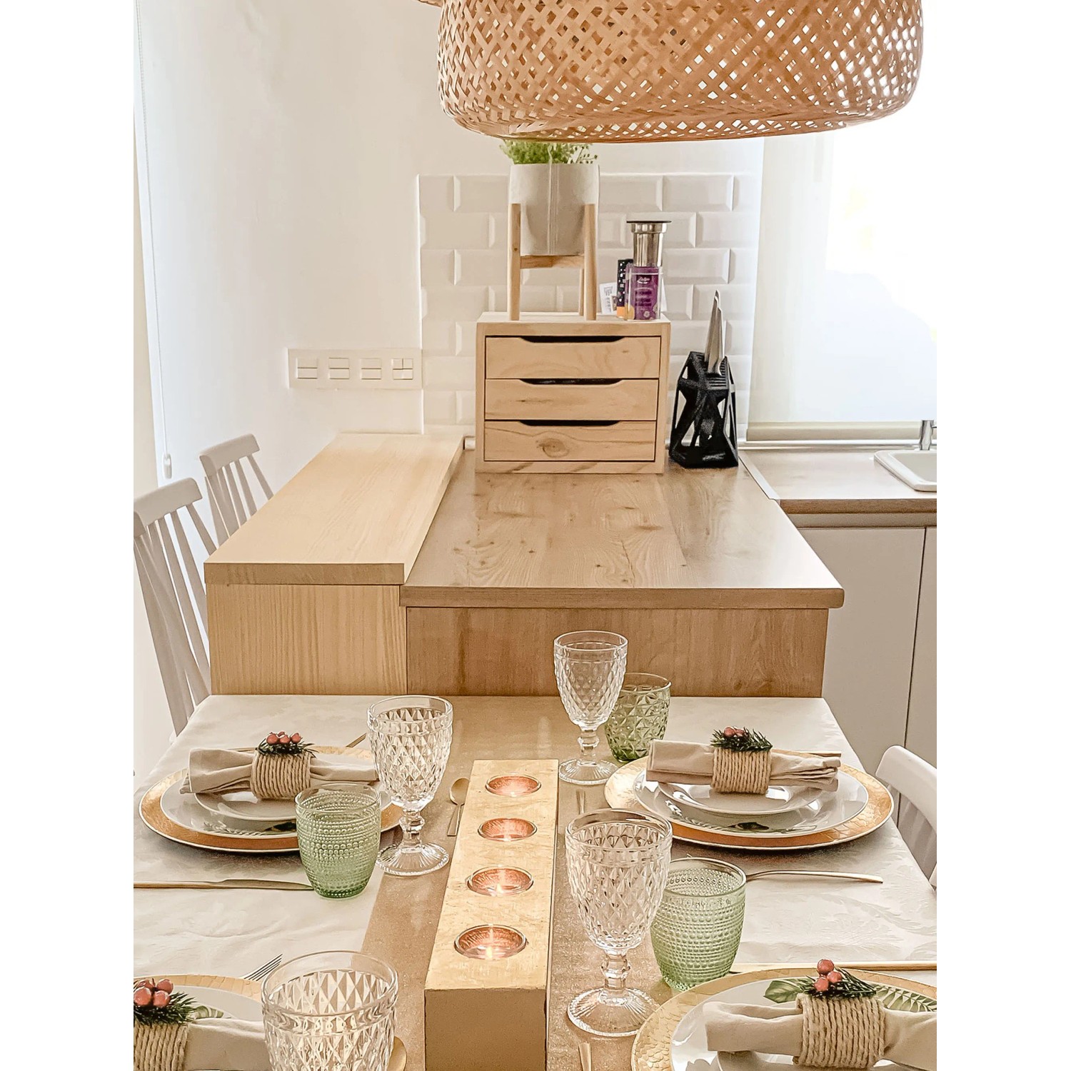 Cassettiera t.b.t. in legno chiaro su un bancone da cucina, abbinata a decorazioni da tavola.