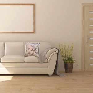 Cuscino decorativo t.b.t. con motivo floreale su divano. Cuscino d'arredo per la casa.