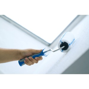 Mano che tiene il rullo LUX Vestan 18 cm (rullo per pittura) mentre dipinge una parete.