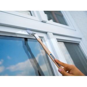 Pennello angolare LUX per verniciatura 25 mm in uso per dipingere un telaio di finestra.