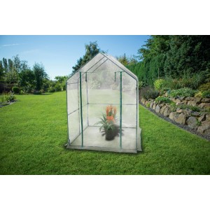 Piccola serra t.b.t. con pianta in giardino.