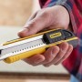 Cutter Stanley FatMax 18mm nero-giallo in mano, coltello per tagli precisi.