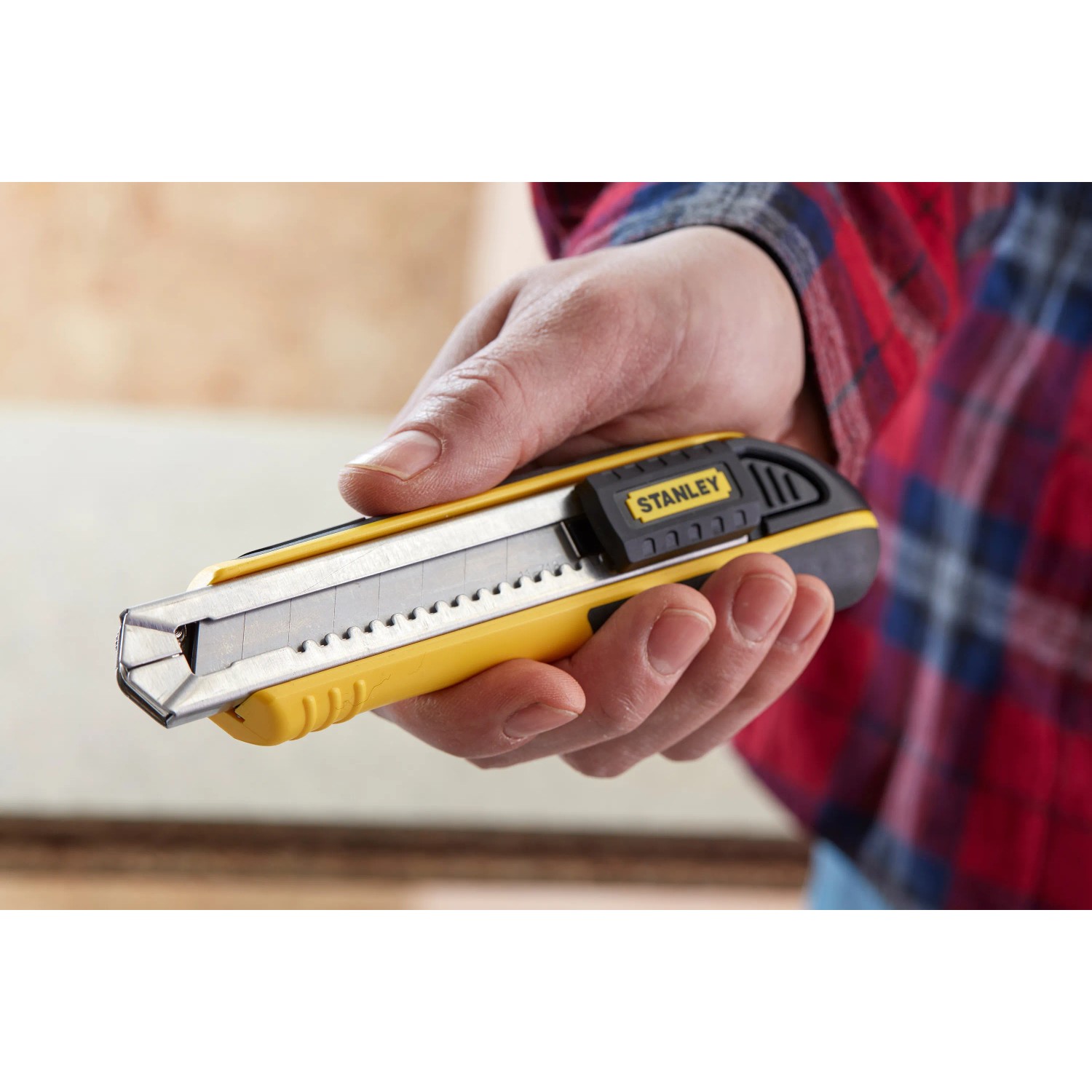 Cutter Stanley FatMax 18mm nero-giallo in mano, coltello per tagli precisi.