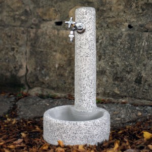 Colonna fontana da giardino grigia con rubinetto.