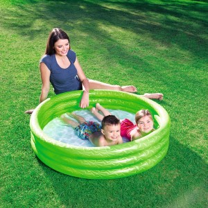 Piscina gonfiabile verde con bambini e adulto in giardino.
