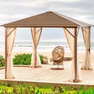 Gazebo marrone t.b.t. con tende e poltrona in rattan sulla spiaggia.
