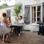 Barbecue a gas nero t.b.t. in giardino con persone che festeggiano.