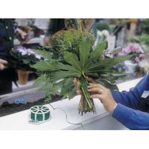Donna che lega bouquet con filo piatto verde (100m).
