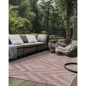 Tappeto da esterno t.b.t. con motivo a zigzag su un patio con mobili da giardino.
