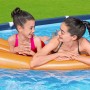 Due ragazze si rilassano su un materassino in piscina. Piscina fuori terra sullo sfondo.