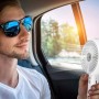 Uomo che usa il ventilatore t.b.t. in auto per rinfrescarsi.