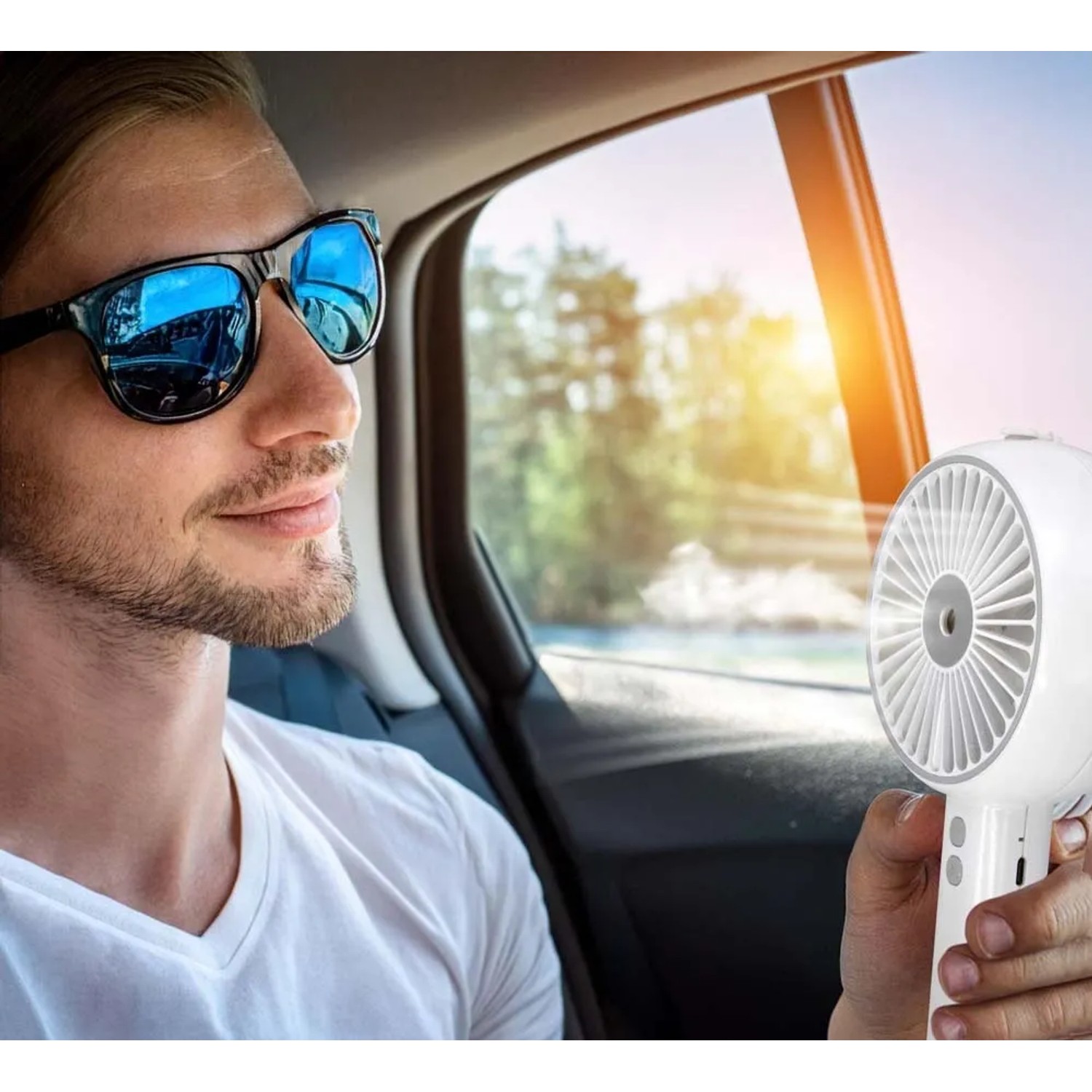 Uomo che usa il ventilatore t.b.t. in auto per rinfrescarsi.
