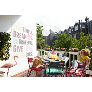 Terrazza con tavolo, sedie, decorazioni e donna. Goditi la sensazione di stare all'aperto.