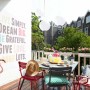Terrazza con tavolo, sedie, decorazioni e donna. Goditi la sensazione di stare all'aperto.