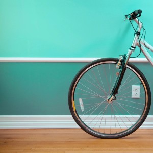 Bicicletta appoggiata a parete turchese. Pitture per interni colorate per accenti vivaci.