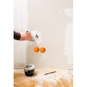 Artigiano che stucca una parete con set spatole giapponesi LUX. Utensile e stucco in uso.