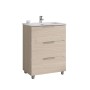 Mobile bagno in legno chiaro con tre cassetti e lavabo da appoggio.