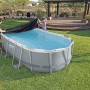 Piscina ovale Bestway con telo di copertura nero in giardino.