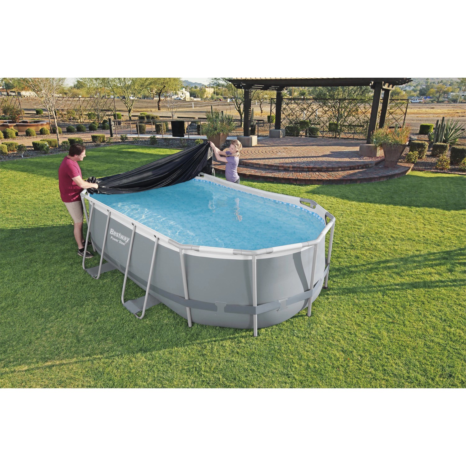 Piscina ovale Bestway con telo di copertura nero in giardino.