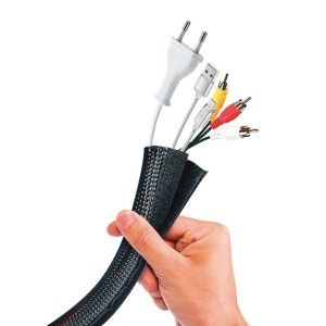 Mano che tiene una guaina per cavi con cavi di alimentazione e dati. Utensile per elettricisti.
