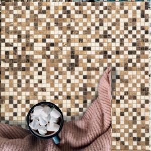 Piastrella a mosaico nei toni del marrone e del beige con tazza e coperta.