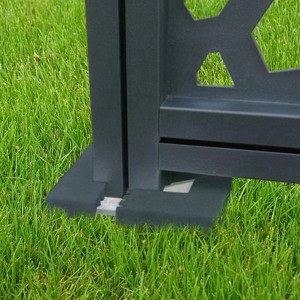 Dettaglio di un traliccio/grigliato grigio su erba. Focus sulla base.