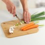 Tagliere in bambù Wenko M+: Taglio di verdure su utensile da cucina in bambù con manico.