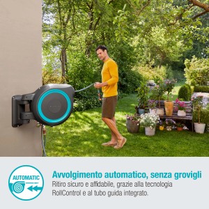 Avvolgitubo a muro con tubo da giardino in uso in giardino.