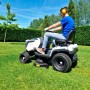 Trattorino tagliaerba mentre taglia l'erba in giardino. Il trattore è bianco e nero.