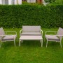 Set di mobili da giardino grigio con panca, tavolo e due sedie su prato.