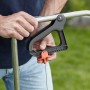 Dettaglio: Mano che aziona lo spargitore Gardena L per distribuire semi o fertilizzante.