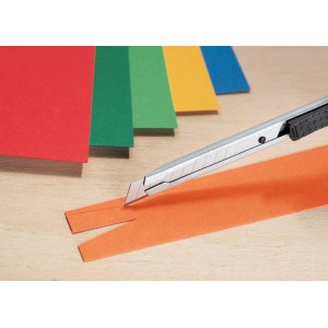 Cutter LUX 9 mm in metallo taglia carta arancione, pila di carta colorata sullo sfondo.