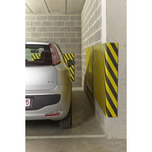Paracolpi giallo-nero in garage accanto all'auto.