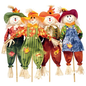 Figure decorative di spaventapasseri con cappelli colorati e salopette come decorazione da giardino.