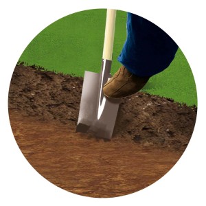 Pala che scava nel terreno, piede sulla lama. Giardinaggio o lavori edili.