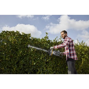 Tagliasiepi a batteria t.b.t. in uso per tagliare una siepe.