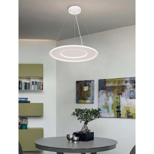 Moderna lampada a sospensione t.b.t. rotonda bianca sopra il tavolo da pranzo.
