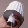 Lampada decorativa da esterno t.b.t. bianca con cavo di ricarica USB tenuta in mano.