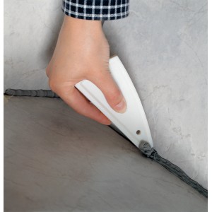 Lisciatrice per fughe LUX in uso: mano che liscia una fuga di silicone grigio su piastrella. Strumento per muratura per giunti puliti.